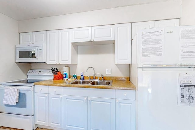 kitchen with white appliances, light countertops, a sink, and white cabinetry