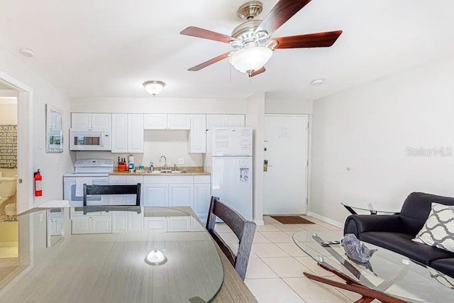 dining area featuring light tile patterned floors, a ceiling fan, and baseboards