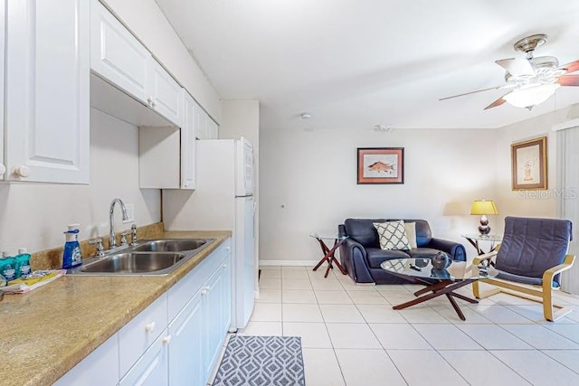 kitchen featuring light tile patterned floors, light countertops, a ceiling fan, white cabinets, and a sink