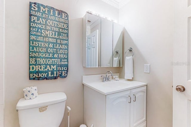 bathroom featuring crown molding, vanity, and toilet