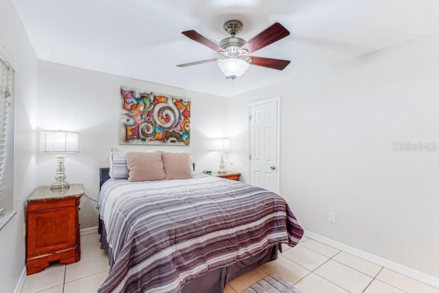 bedroom featuring light tile patterned floors, baseboards, and a ceiling fan