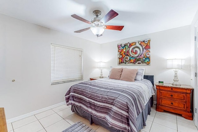 bedroom with ceiling fan, baseboards, and light tile patterned floors