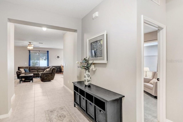 hall with light tile patterned flooring and baseboards