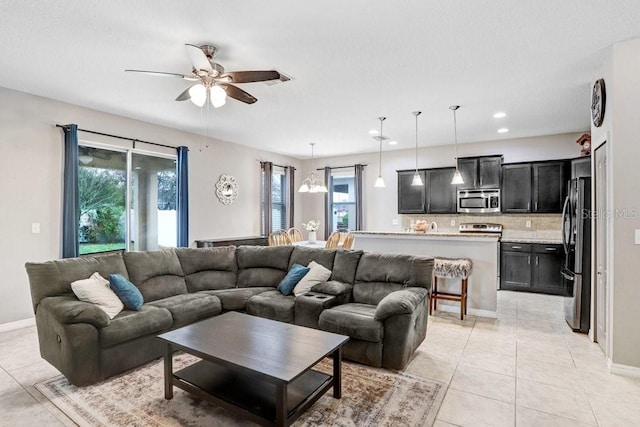 living area featuring light tile patterned floors, recessed lighting, plenty of natural light, and baseboards