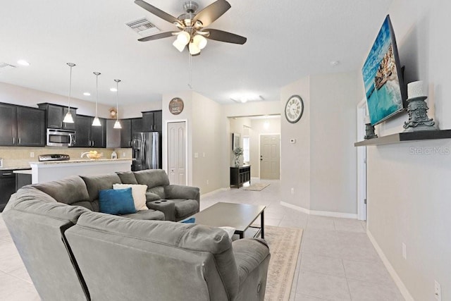 living area with a ceiling fan, light tile patterned flooring, visible vents, and baseboards