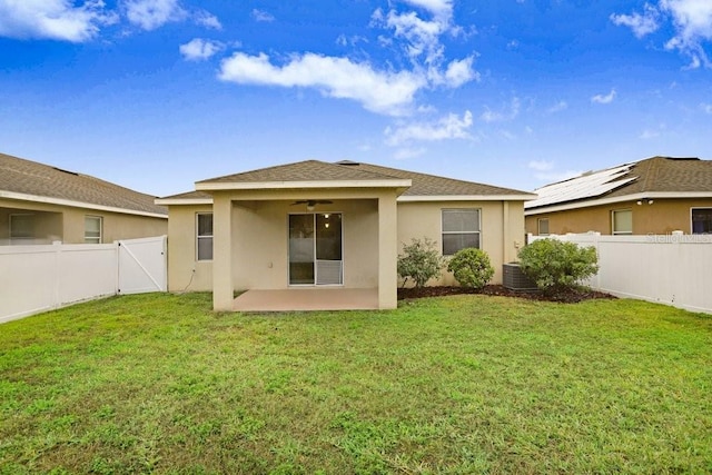 back of house featuring a patio, a lawn, a fenced backyard, and stucco siding