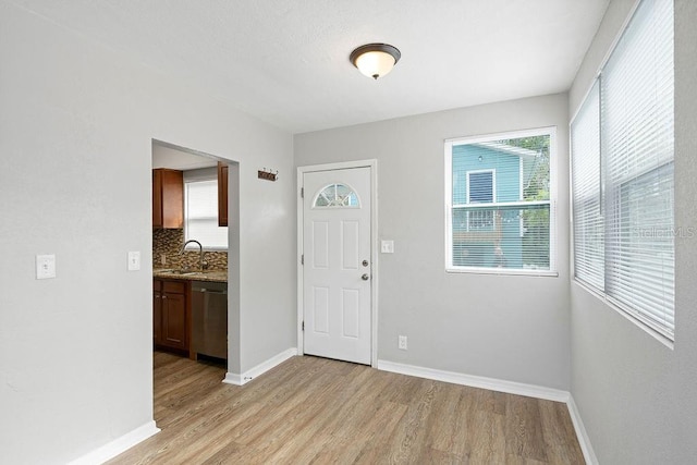 entryway with light wood-type flooring and baseboards