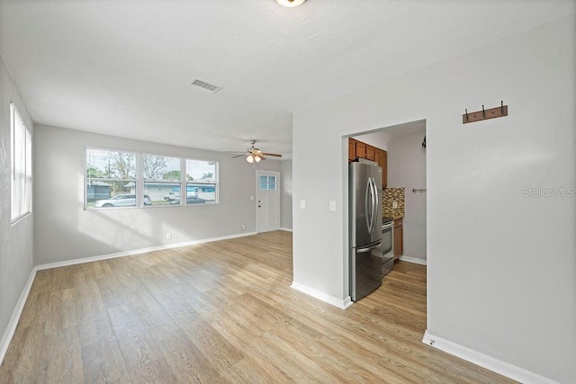 spare room featuring light wood-style floors, visible vents, ceiling fan, and baseboards