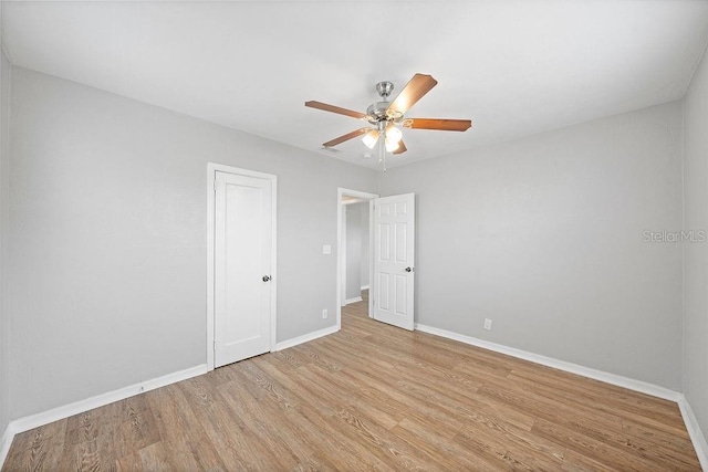 unfurnished room with light wood-style floors, baseboards, and a ceiling fan