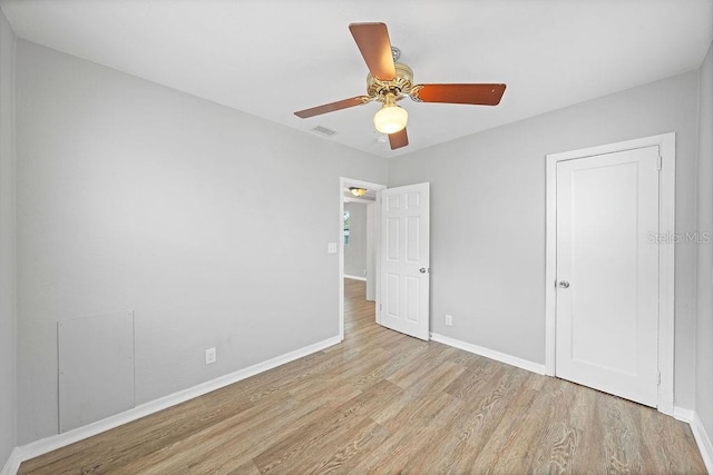 interior space with light wood-style floors, visible vents, baseboards, and a ceiling fan