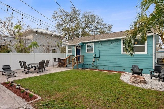 back of property with a fire pit, fence, crawl space, a lawn, and a patio area