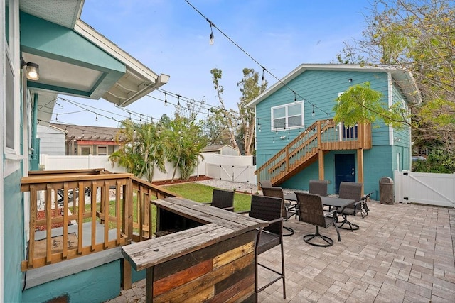 exterior space with outdoor dining space, stairway, a fenced backyard, and a gate