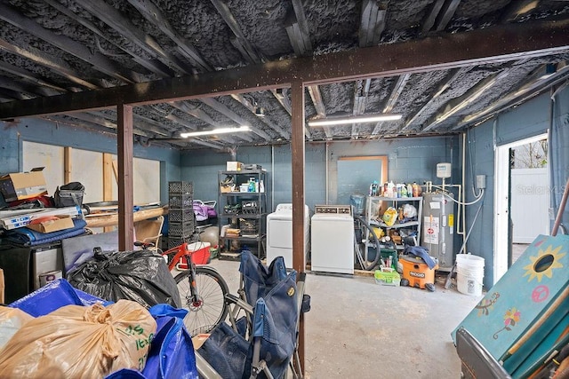 unfinished below grade area with washer and clothes dryer, electric water heater, and concrete block wall