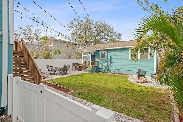 back of house with a fenced backyard, stairway, a patio, and a yard