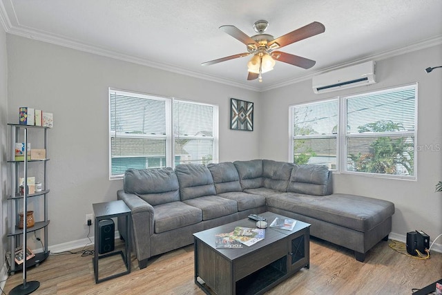 living area with light wood finished floors, baseboards, a ceiling fan, ornamental molding, and a wall mounted air conditioner