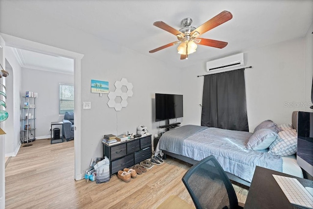 bedroom with a ceiling fan, a wall mounted air conditioner, light wood-style flooring, and baseboards