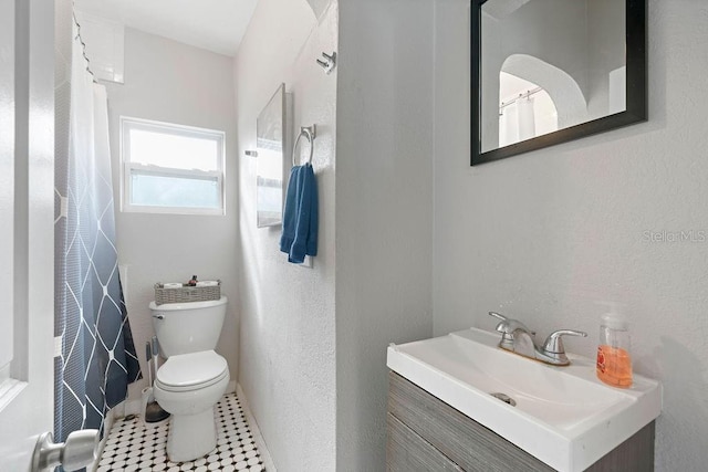 bathroom with toilet, a shower with curtain, tile patterned flooring, and vanity