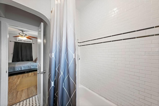 ensuite bathroom with shower / tub combo, wood finished floors, a ceiling fan, and ensuite bathroom