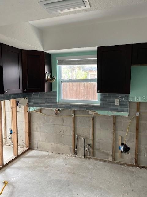 kitchen featuring visible vents, unfinished concrete floors, and concrete block wall