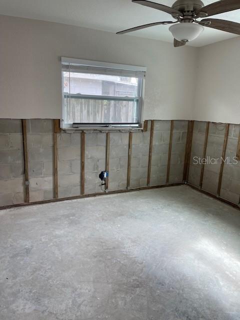 spare room featuring a ceiling fan and concrete flooring