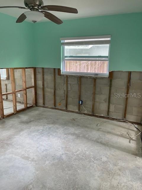 spare room featuring a ceiling fan and concrete flooring