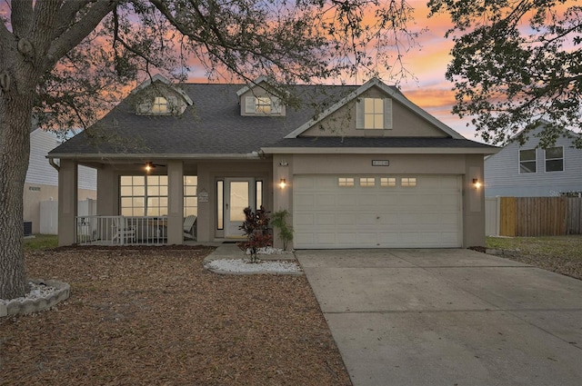 view of front of property with a garage, concrete driveway, roof with shingles, a porch, and stucco siding