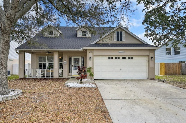 view of front of property featuring roof with shingles, stucco siding, a porch, a garage, and driveway