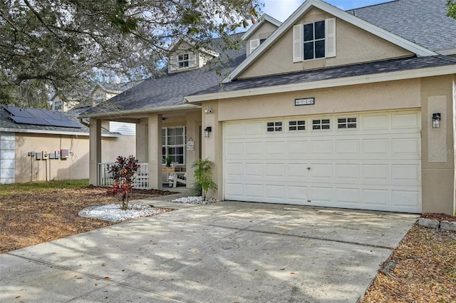 view of front of house with driveway, a shingled roof, and stucco siding