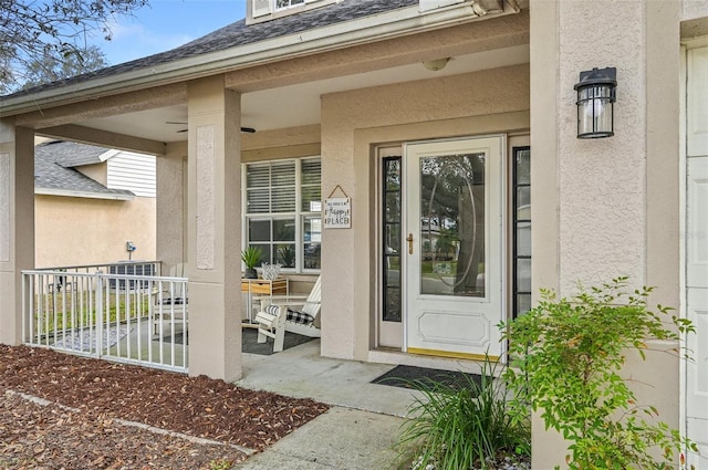 property entrance featuring stucco siding and roof with shingles