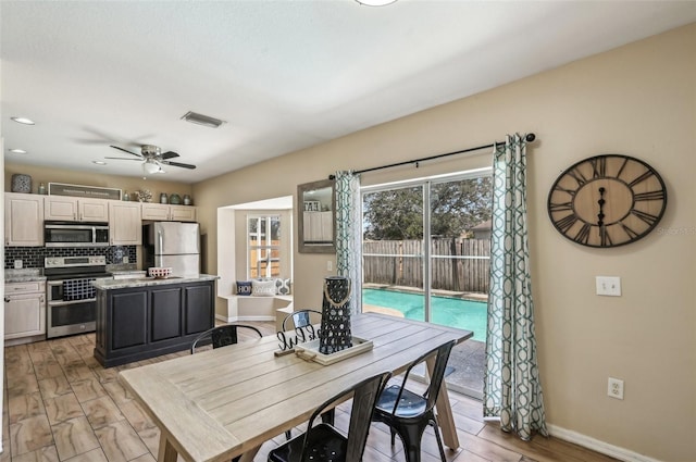 dining area featuring ceiling fan, light wood-style floors, visible vents, and baseboards