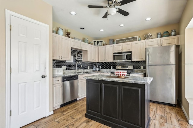 kitchen featuring appliances with stainless steel finishes, a center island, ceiling fan, and tasteful backsplash