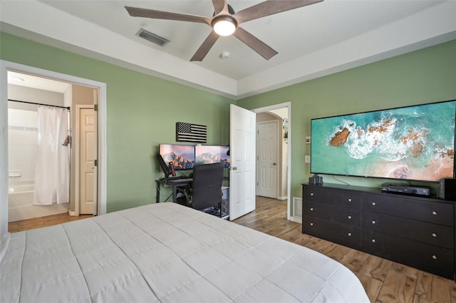 bedroom featuring baseboards, visible vents, connected bathroom, ceiling fan, and wood finished floors