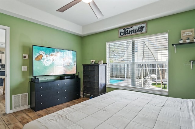 bedroom featuring dark wood-type flooring, visible vents, and a ceiling fan