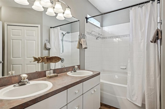 bathroom with double vanity, a closet, shower / bath combo with shower curtain, and a sink