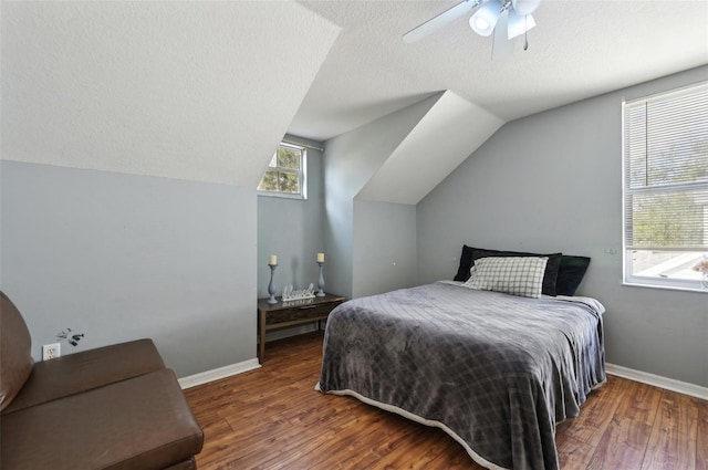 bedroom featuring dark wood-style floors, vaulted ceiling, and baseboards