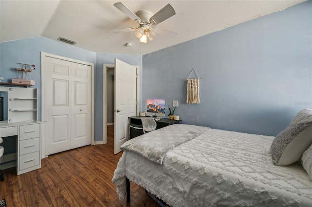 bedroom with dark wood-type flooring, visible vents, a ceiling fan, vaulted ceiling, and a closet