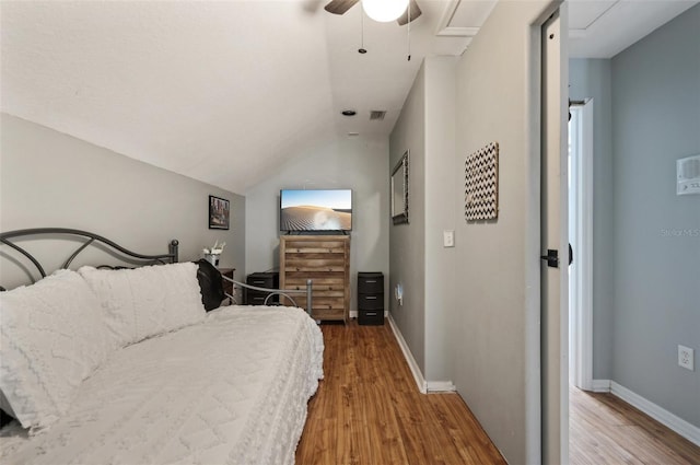 bedroom with visible vents, vaulted ceiling, light wood-style flooring, and baseboards