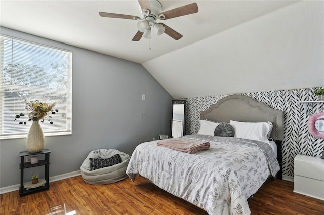 bedroom with a ceiling fan, lofted ceiling, dark wood finished floors, and baseboards