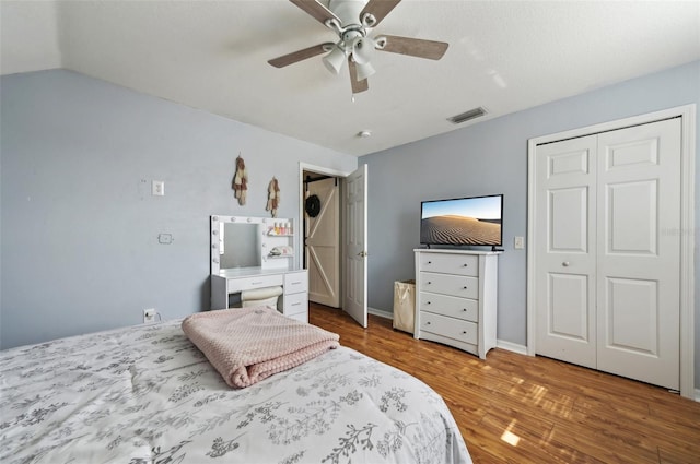 bedroom featuring baseboards, visible vents, ceiling fan, wood finished floors, and vaulted ceiling