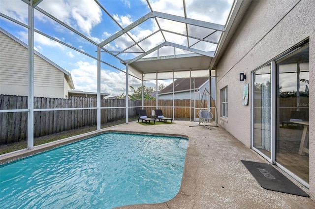 view of swimming pool with glass enclosure, a fenced backyard, a fenced in pool, and a patio