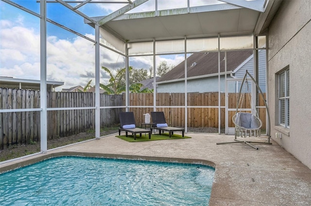 view of swimming pool with a patio, glass enclosure, a fenced backyard, and a fenced in pool