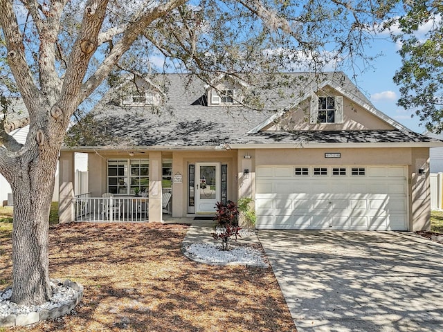 view of front of home with a garage, covered porch, concrete driveway, and stucco siding