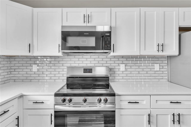 kitchen featuring appliances with stainless steel finishes, tasteful backsplash, light countertops, and white cabinetry