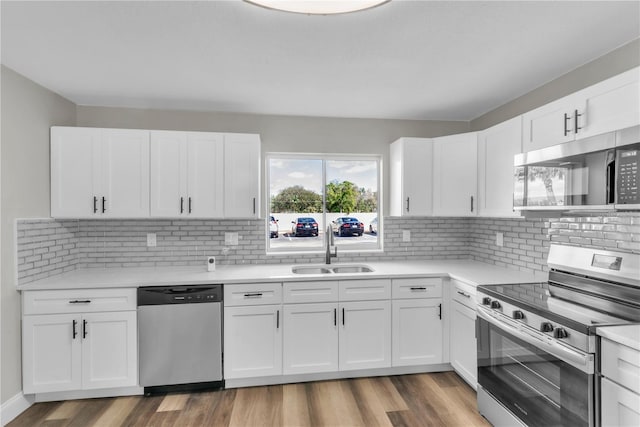 kitchen with wood finished floors, light countertops, appliances with stainless steel finishes, and a sink