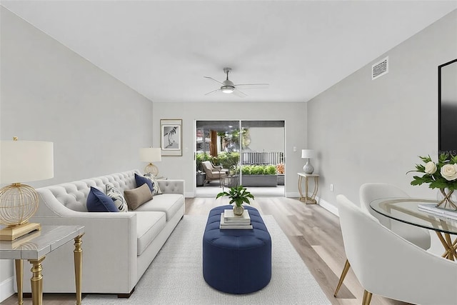 living area with a ceiling fan, baseboards, visible vents, and wood finished floors