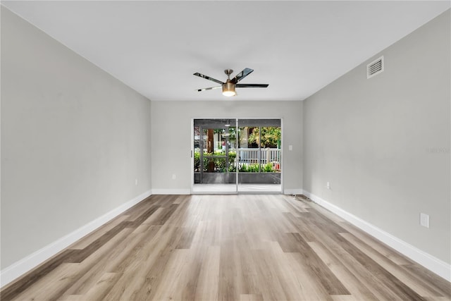 unfurnished room featuring ceiling fan, wood finished floors, visible vents, and baseboards