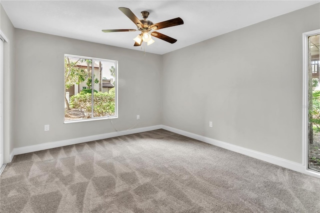 carpeted spare room with ceiling fan and baseboards