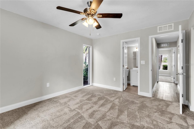 unfurnished bedroom with baseboards, visible vents, carpet flooring, and multiple windows