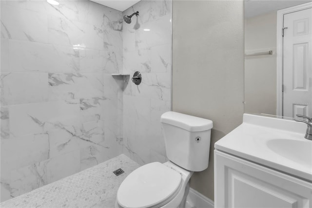 bathroom with toilet, a textured wall, a marble finish shower, and vanity