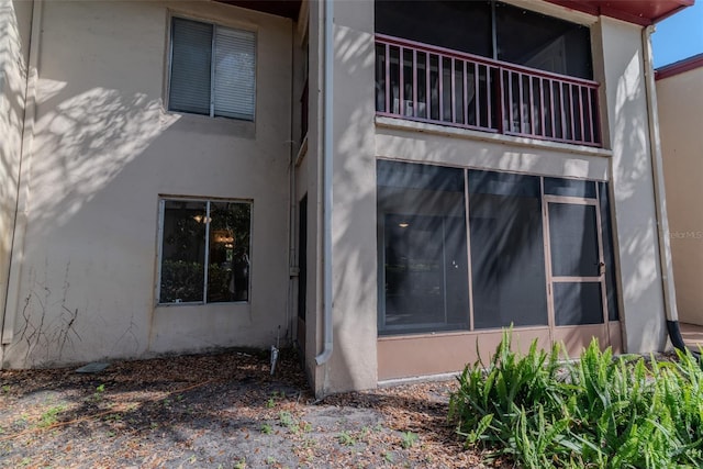 view of side of home featuring a balcony and stucco siding